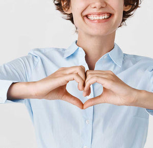 the lady wear blue made a heart-shape gesture in front of her chest