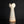 將圖片載入到圖庫檢視器中， A small sculptural ceramic vase with a tall, flared, tulip-like top and a narrow tapered body, shown on a glossy black surface against a black background.
