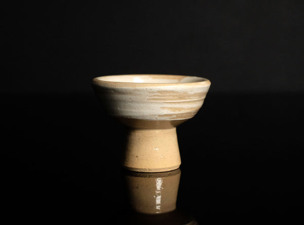 Ceramic sake cup on a black reflective surface