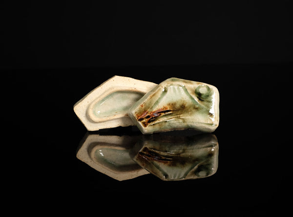 A sculptural ceramic incense box (kōgō) by Ayukai Kōgetsu, modelled in a stylised Mount Fuji form. Its low, angular silhouette combines softly raised contours with flowing cream, olive-green and brown glazes.

The lid rises towards an irregular summit, with sloping sides suggesting the mountain’s distinctive outline. Uneven ridges and gently softened edges give the piece an organic character, interpreting the subject through expressive modelling rather than precise symmetry.
