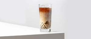 A glass of bubble milk tea on a white table