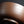 Load image into Gallery viewer, A close-up of a brown ceramic bowl with horizontal grooved lines, photographed against a dark black background.
