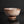 將圖片載入到圖庫檢視器中， A handmade ceramic bowl with a textured, speckled brown and white glaze, standing on a small matching base against a dark reflective background.
