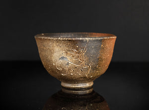 Ceramic bowl with dragon design on a dark background