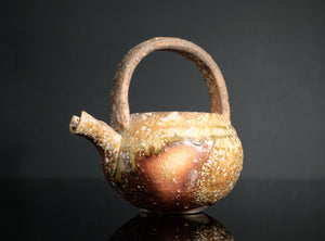 Ceramic a shigaraki handled sake ewer with a unique design on a black background