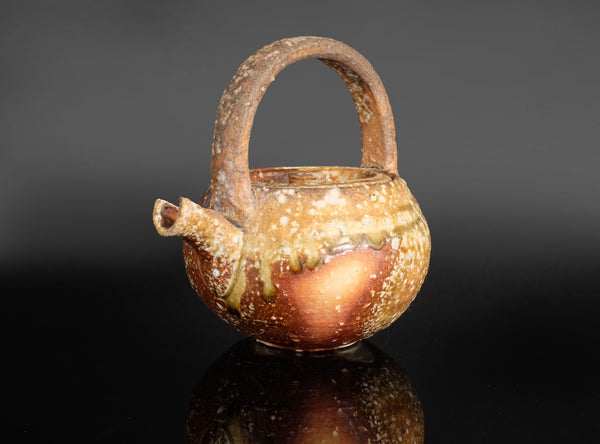 Ceramic a shigaraki handled sake ewer with a unique design on a black background