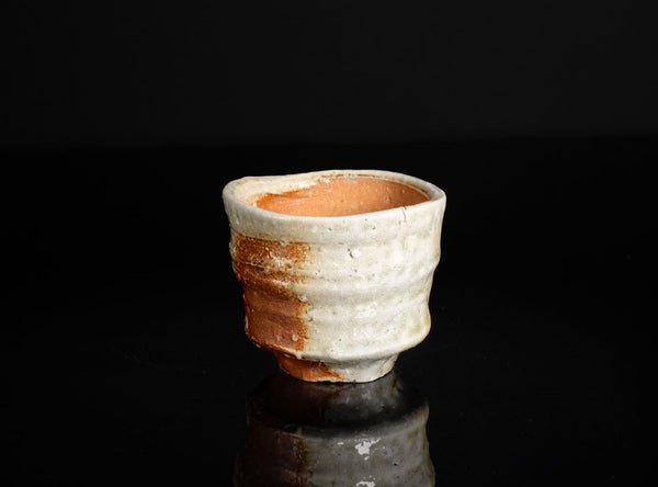 Ceramic cup with textured surface on a black background