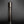 將圖片載入到圖庫檢視器中， A dark metallic cylindrical flower vase standing upright on a reflective black surface against a dark gray gradient background.
