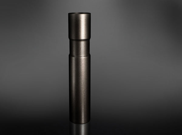 A dark metallic cylindrical flower vase standing upright on a reflective black surface against a dark gray gradient background.