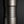 將圖片載入到圖庫檢視器中， Close-up of a dark metallic cylindrical flower vase standing upright on a reflective black surface against a dark gray gradient background.
