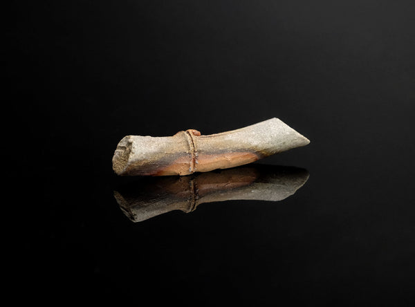 A Set of Five Bizen Chopstick Rests with a metallic sheen on a black reflective surface
