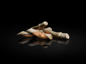 A Set of Five Bizen Chopstick Rests with a metallic sheen on a black reflective surface