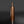 Load image into Gallery viewer, A metallic copper-colored cylindrical container or grinder with a small top tube, standing upright on a reflective dark surface against a dark gray background.
