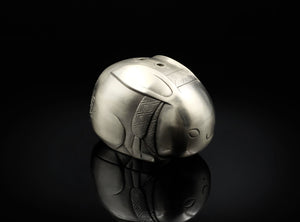 Silver rabbit-shaped object on a black background