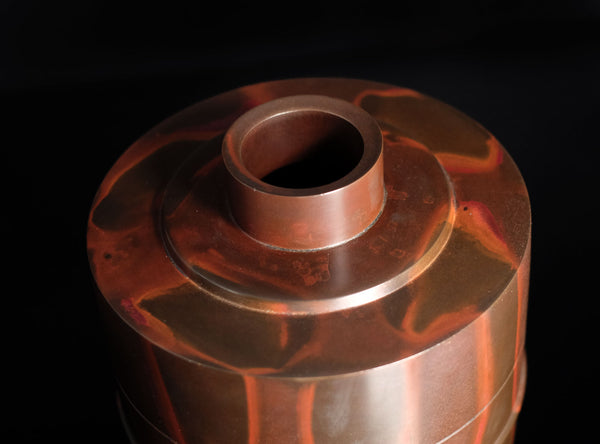 A Shudo Bronze Vase with layered design on a dark background