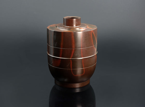 A Shudo Bronze Vase with layered design on a dark background