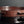 Load image into Gallery viewer, A close-up of a round reddish-brown cast bronze tray with a segmented rim and engraved concentric circle details, displayed on a dark reflective surface.
