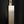 Load image into Gallery viewer, A modernist rectangular metal sculpture with a textured, speckled finish, featuring a vertical slot on its top cap, set against a dark reflective background.
