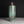 Load image into Gallery viewer, An antique-style cylindrical bronze vase with a green patina and geometric grid engravings, set against a dark gray background.
