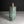 Load image into Gallery viewer, An antique-style cylindrical bronze vase with a green patina and geometric grid engravings, set against a dark gray background.
