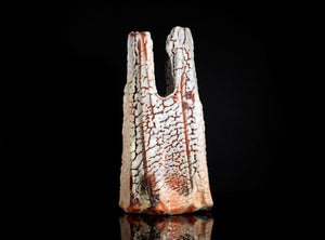Decorative ceramic piece with textured surface on a black background