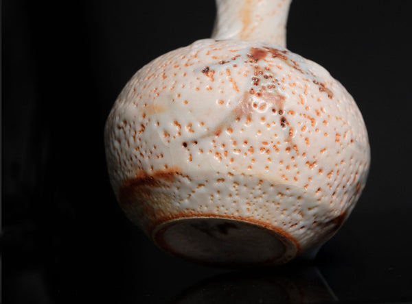 Ceramic vase with textured surface on a black background