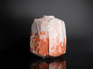 Decorative ceramic vase with textured surface on a black background