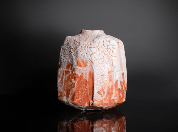 Decorative ceramic vase with textured surface on a black background