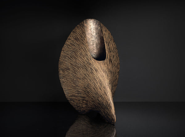 An Inlaid Sculptural Vessel with a dark brown finish on a black background