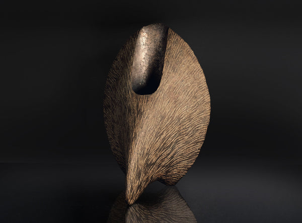 An Inlaid Sculptural Vessel with a dark brown finish on a black background