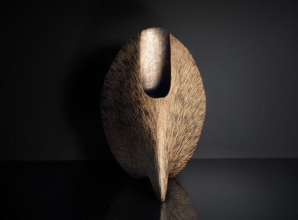 An Inlaid Sculptural Vessel with a dark brown finish on a black background