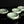 Load image into Gallery viewer, Four light green celadon ceramic bowls with a crackle glaze, arranged on a reflective black surface against a dark background.
