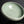 Load image into Gallery viewer, A ceramic bowl with a pale celadon green glaze and a prominent crackle pattern, shown on a dark reflective surface.
