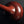 Load image into Gallery viewer, A glossy reddish-brown cast bronze vase with a bulbous base and a long, slender neck, standing on a dark reflective surface against a dark gray background.
