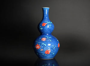 Blue vase with floral designs on a dark background