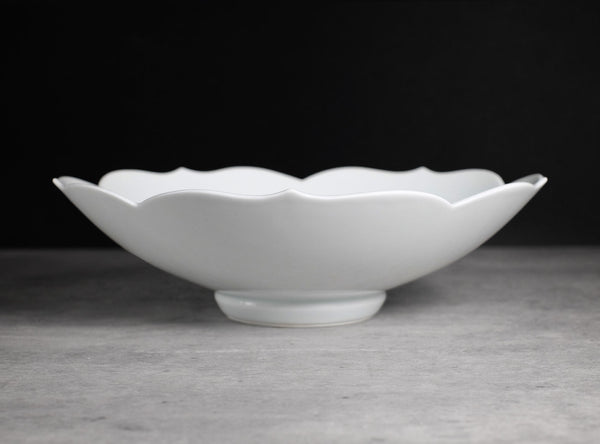 White ceramic plate with scalloped edge on a gray surface