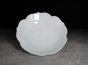 White ceramic plate with floral design on a dark background