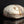Load image into Gallery viewer, A handmade ceramic lidded box with a textured, organic-shaped cream and brown glazed top and a rustic dark brown base, displayed on a reflective black surface against a black background.
