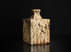 Square ceramic vase with leaf pattern on a black background