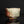 Load image into Gallery viewer, A handmade ceramic bowl with a rustic, hand-painted glaze featuring a mix of brown, green, and off-white colors, displayed on a reflective black surface against a dark background.
