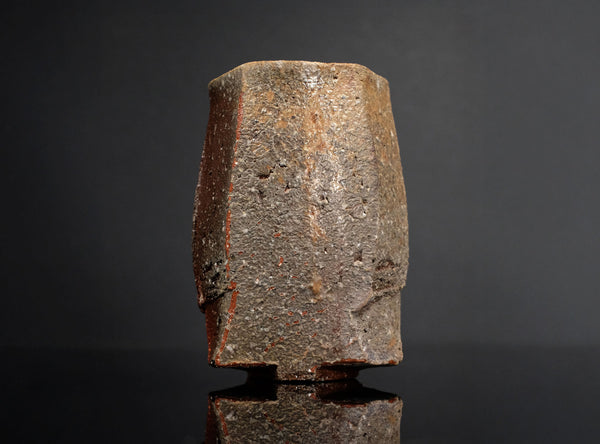 Textured cylindrical ceramic cup a dark background