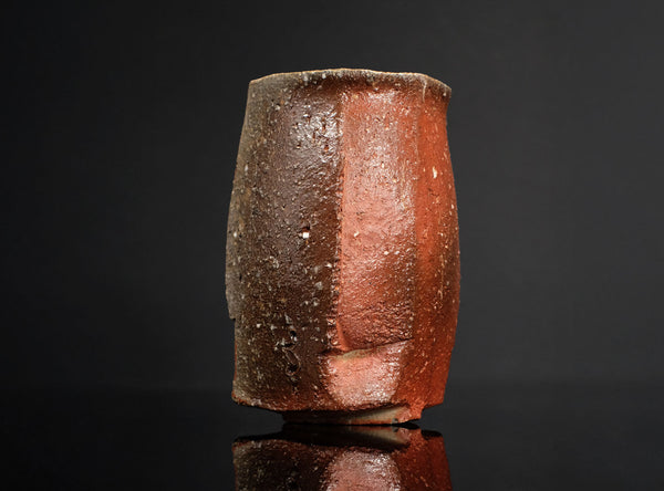 Cylindrical ceramic cup with a gradient finish on a black background