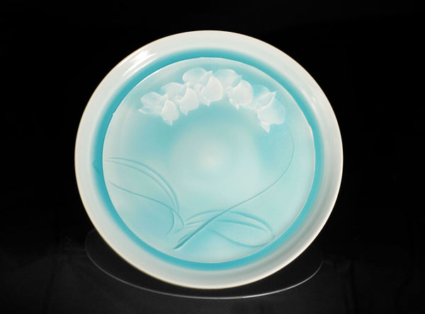 Round ceramic dish with floral design on a black background