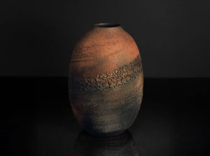 Textured ceramic vase on a dark background