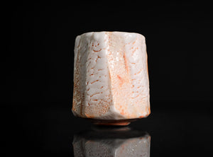 Ceramic cup with textured surface on a black background