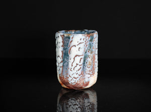 Ceramic cup with textured surface on a black background