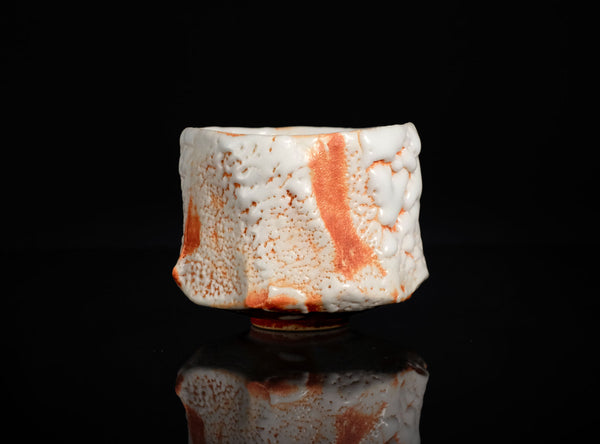 Ceramic cupwith textured surface on a black background