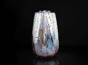 Ceramic vase with textured surface on a black background