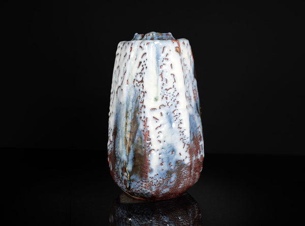 Textured ceramic vase on a black background