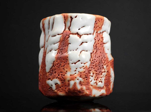 Decorative ceramic piece with textured surface on a black background